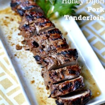 closeup of sliced Honey Dijon Pork Tenderloin recipe on a white rectangle plate