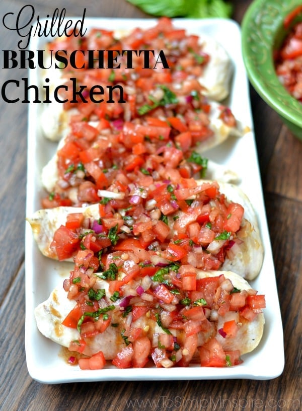 closeup of 5 chicken breasts topped with bruschetta tomato sauce with text overlay \"Grilled Bruschetta Chicken\"