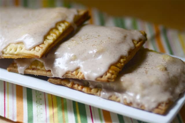 three homemade apple pie pop tarts on a white plate