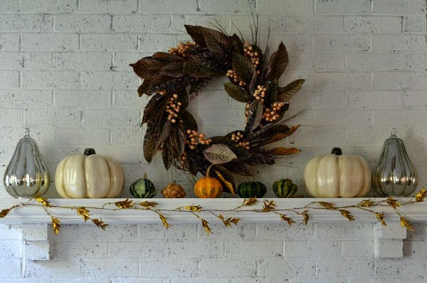 fall leaf wreath on a white mantle with white pumpkins and gourds