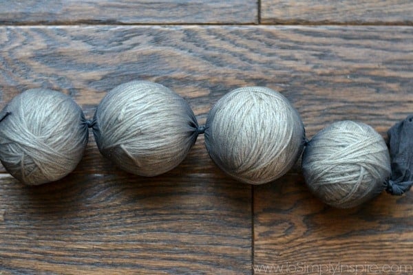 three wool dryer balls stuffed in black panty hose