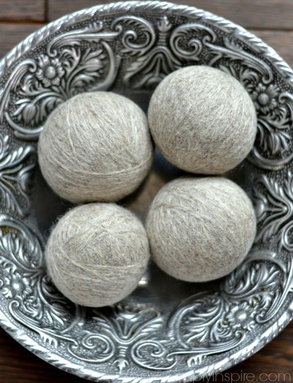 Four gray wool balls in a silver bowl
