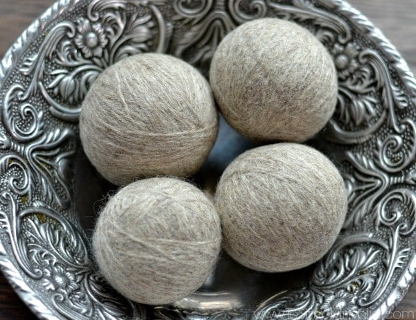 Four gray DIY wool dryer balls in a silver bowl