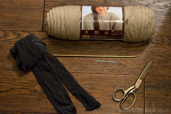 skein of wool yarn, scissors and black pantyhose on a wood table
