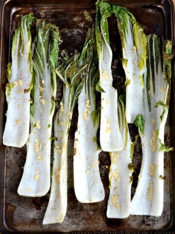 closeup of 8 stalks of Garlic Roasted Bok Choy recipe on a baking sheet