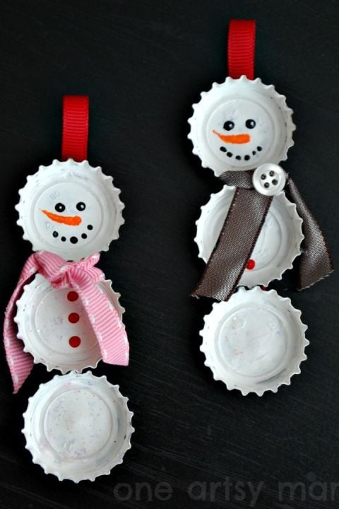 a closeup of two DIY bottle cap snowmen Christmas ornament 