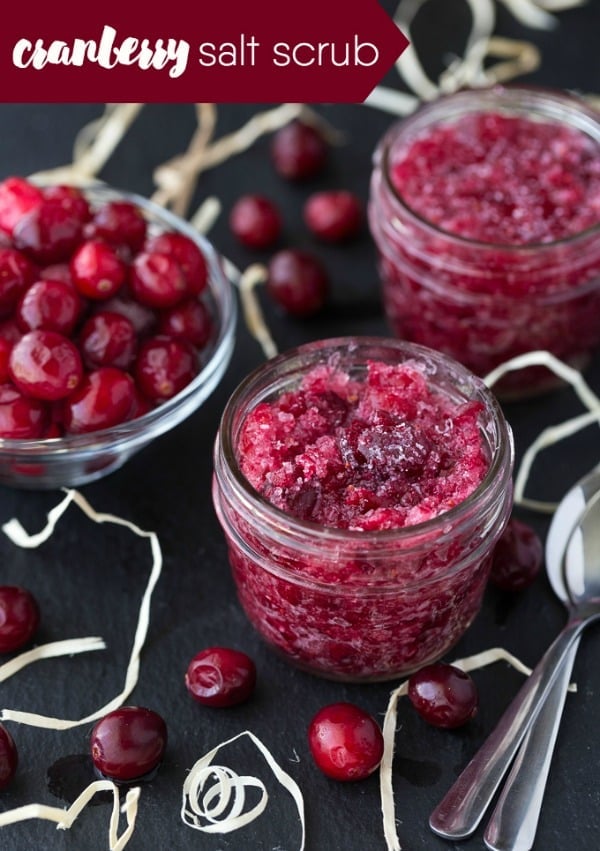 Cranberry salt scrub in a mason jar with a bowl of cranberries beside 