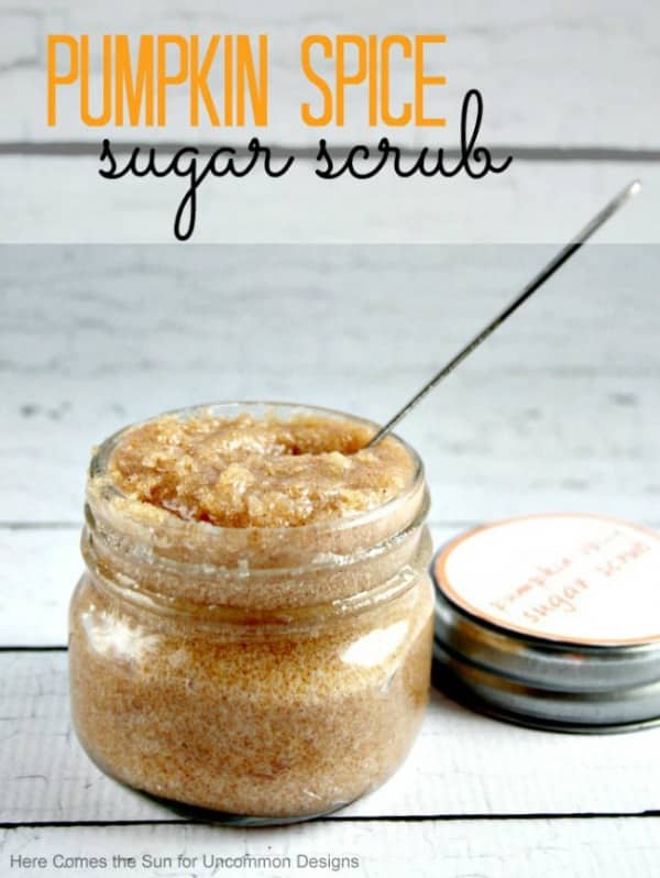 A close up of a coffee sugar scrub in a glass jar with a spoon