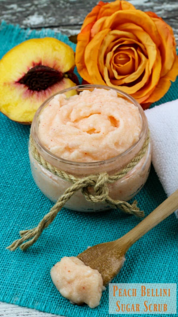 peach sugar scrub in a small jar with jute tie with peach slice behind