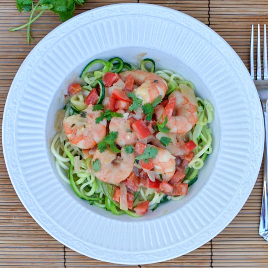 shrimp on top of zucchini noodles in a white bowl