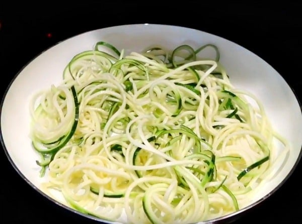 uncooked zucchini noodles in a white pan