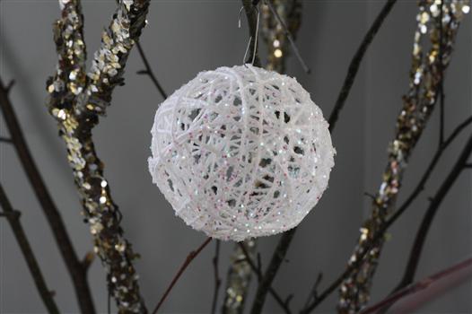 A close up of a glittery snowball ornament