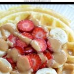 waffle with strawberries and bananas on top with peanut butter drizzle