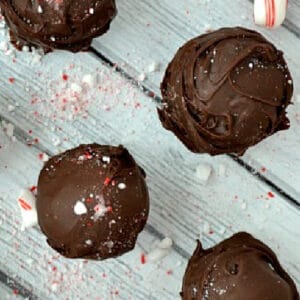 several chocolate covered oreo balls on a wood table