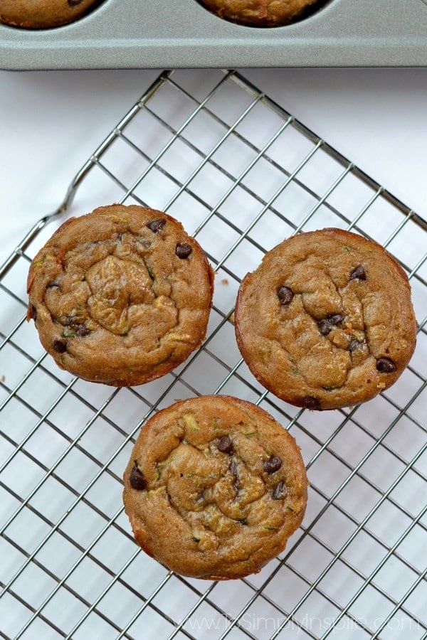 closeup of 3 gluten free zucchini muffins on a wire cooling rack