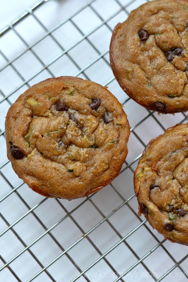 closeup of 3 gluten free zucchini muffins on a wire cooling rack