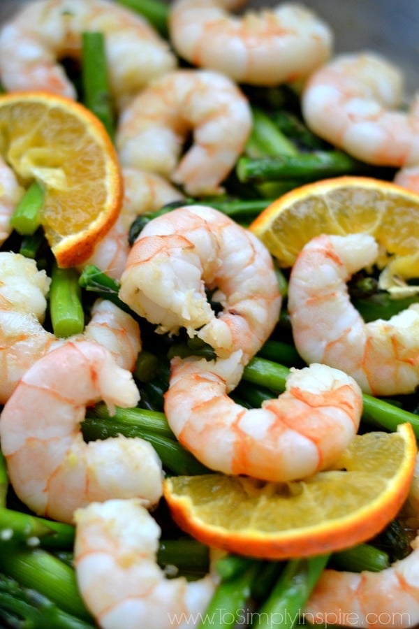 Closeup of Orange Garlic Shrimp with Asparagus Recipe with orange slices on top