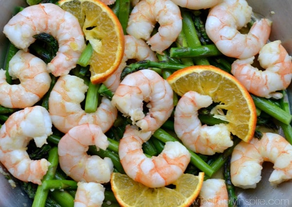 Closeup of Orange Garlic Shrimp with Asparagus Recipe with orange slices on top