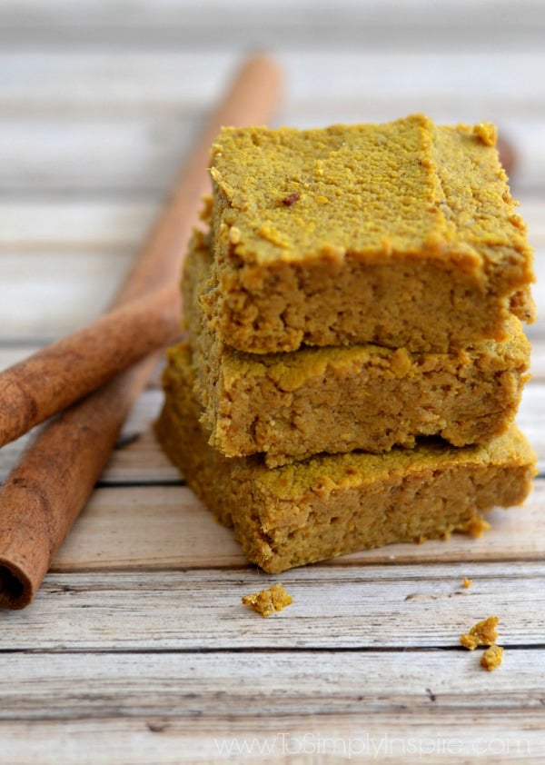 close-up of 3 Pumpkin Pie Bars stacked on top of each other beside 2 cinnamon sticks