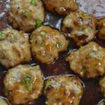 Closeup of a panful Teriyaki Chicken Meatballs Recipe in a brown sauce.