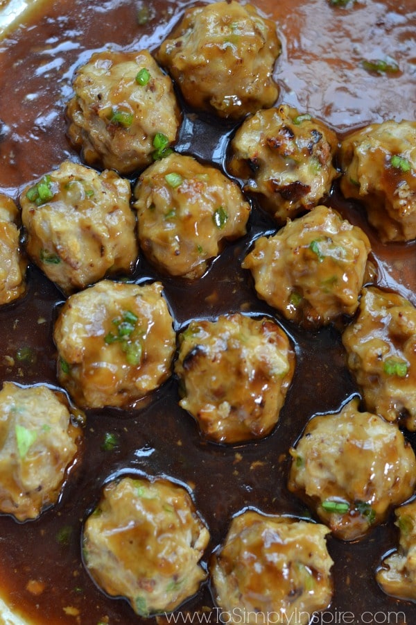 Closeup of a panful Teriyaki Chicken Meatballs Recipe in a brown sauce.