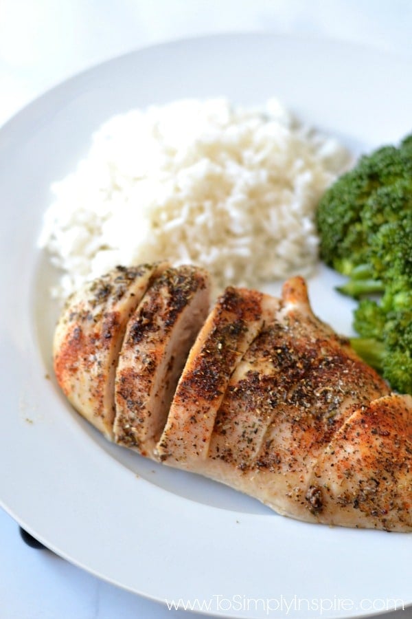 Baked Chicken breast on a white plate with rice and broccoli  