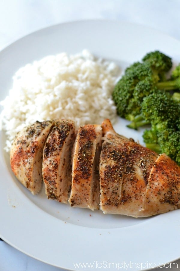 Baked Chicken breast on a white plate with rice and broccoli  