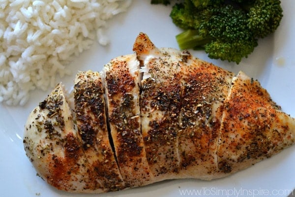 Baked Chicken breast on a white plate with rice and broccoli  