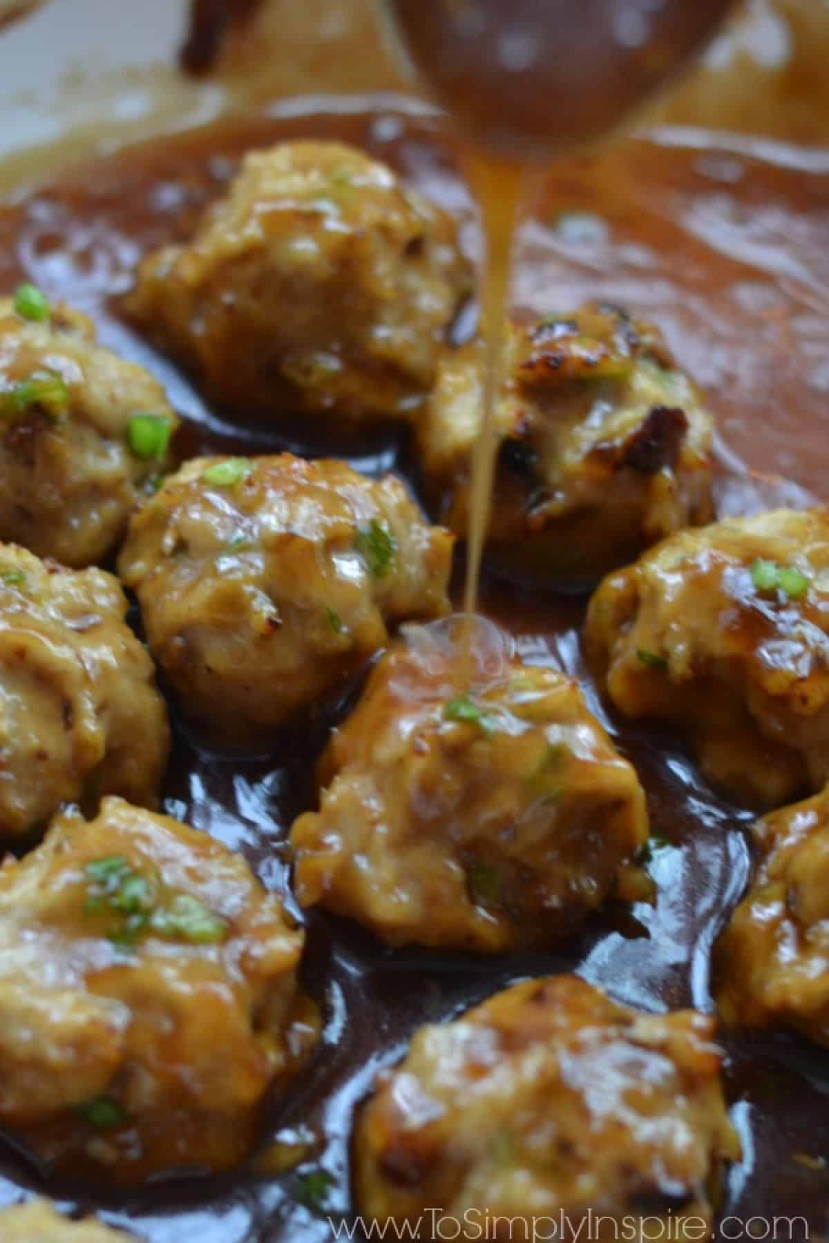 Closeup of Teriyaki Chicken Meatballs Recipe with sauce being poured over top. 