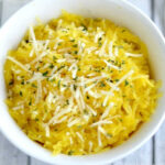 white bowl with spaghetti squash topped with parmesan cheese