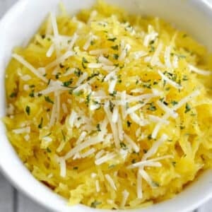 white bowl with spaghetti squash topped with parmesan cheese