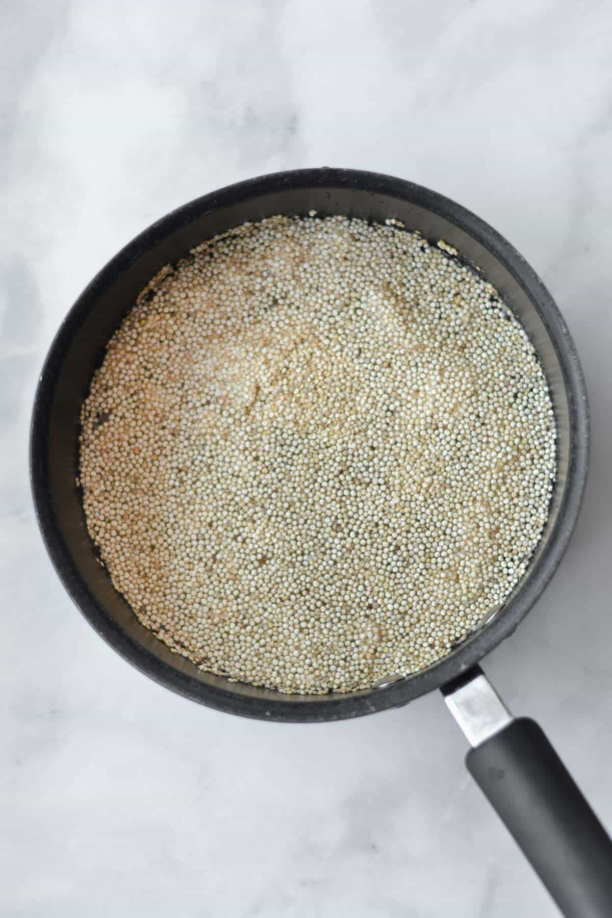 uncooked quinoa in a black pot