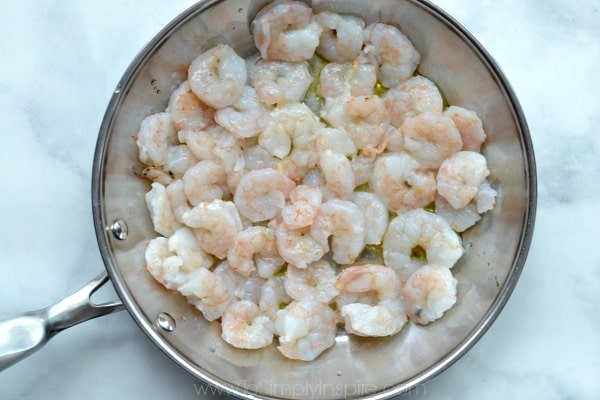 uncooked shrimp in a stainless steel pan