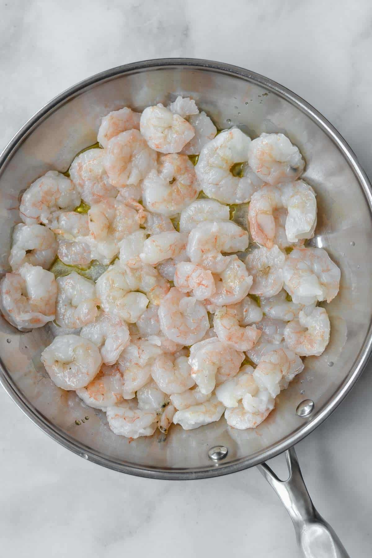 uncooked shrimp in a stainless steel pan