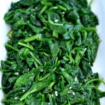 Sauteed spinach with garlic on a white plate.