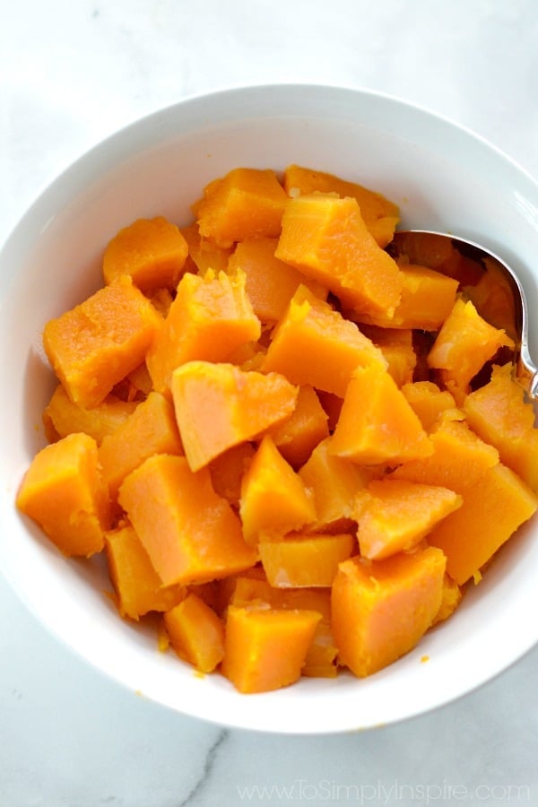 a bowl of cubed butternut squash in a white bowl