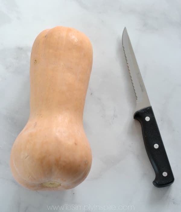 whole butternut squash and a knife on a countertop 