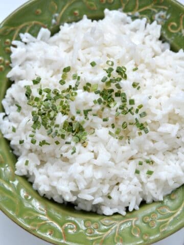 A green bowl of white rice with chives