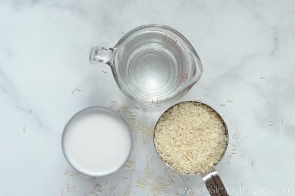 coconut milk can, cup of uncooked rice and a measuring cup of water.