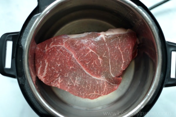 raw chuck roast sitting in an empty instant pot