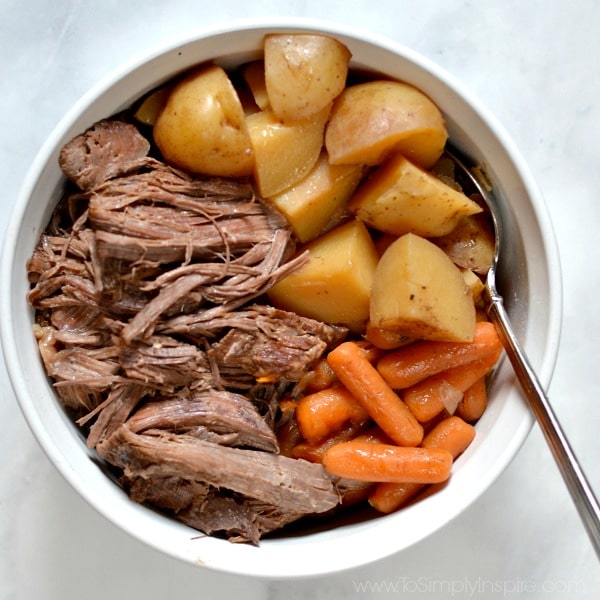 A white bowl is filled with Pot Roast and Gravy