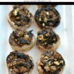 eight stuffed mushrooms lined up on a white plate