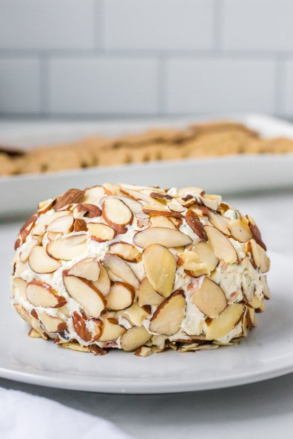 bacon dill cheese ball covered with almonds on a white plate