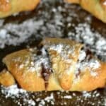 crescent roll baked with nutella on the inside and sprinkled with powdered sugar.