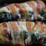 closeup of chicken breast stuffed with spinach and cream sheese mixture and then wrapped in bacon