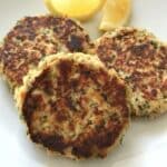 three tuna patties on a white plate.