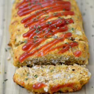 closeup of turkey meatloaf topped with ketchup and a slice cut off the end.