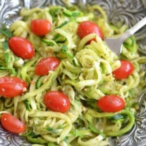 zucchini noodles with cherry tomatoes in a silver bowl