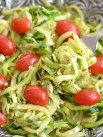 zucchini noodles with cherry tomatoes in a silver bowl