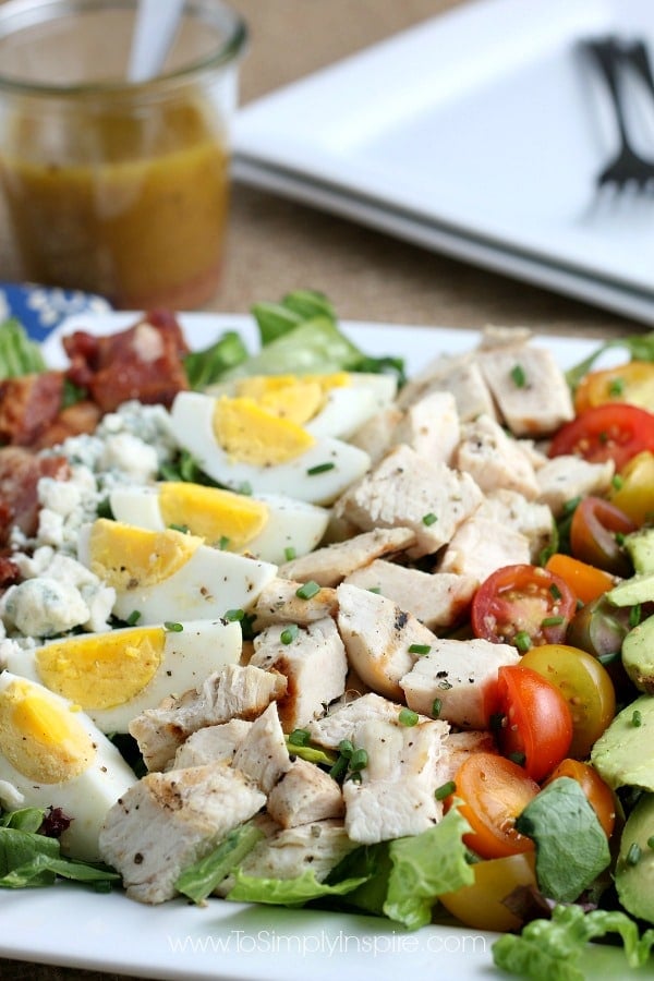 Closeup of layered Cobb Salad on a rectangle white plate